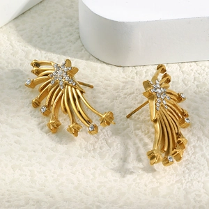Détail macro de boucles d'oreilles ailes en plaqué or 18K avec zircons blancs