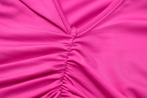 Detailed close-up of V-neckline and gathered pleats on this rose pink midi dress