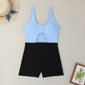 Flat lay of a color-block cutout one-piece swimsuit with boyleg shorts and beach accessories