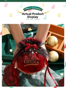 Macro detail of red velvet Christmas apple gift bag with gold Merry Christmas lettering