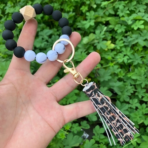 Detail of beaded keychain bracelet with leopard print tassel and gold ring clasp