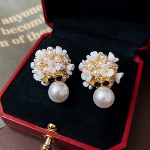 Elegant floral pearl drop earrings with zircon and gold finish in a red jewelry box