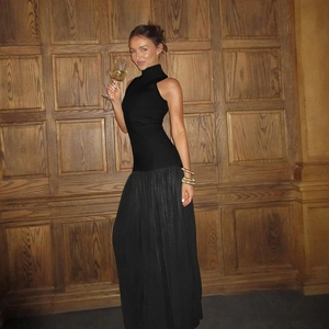 Elegante abito lungo nero senza maniche con collo alto e gonna in mesh a pois trasparente