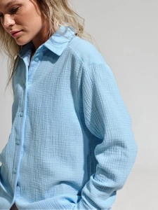 Detail of light blue cotton gauze shirt fabric texture and minimalist button-down collar