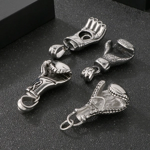 Détail de quatre pendentifs gants de boxe en acier inoxydable sur un fond noir texturé