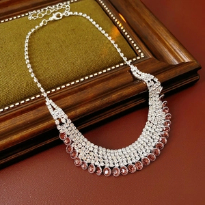 Detail of silver necklace with champagne pink gemstones and clear rhinestones on velvet