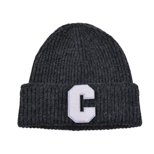 Close-up of charcoal gray knit beanie with a white plush letter C patch detail