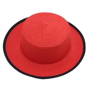 Top view of red woven boater hat with black ribbon edge detailing and straw texture