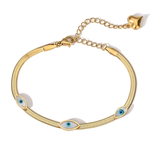 Golden evil eye snake chain bracelet with heart charm on a minimalist white background