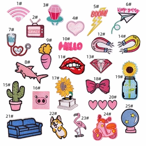 Flat lay of 25 colorful cartoon embroidery patches featuring various cute designs