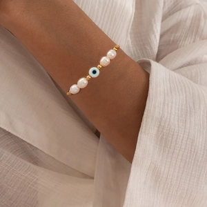 Handmade woven bracelet featuring Baroque pearls and a blue Evil Eye charm for women