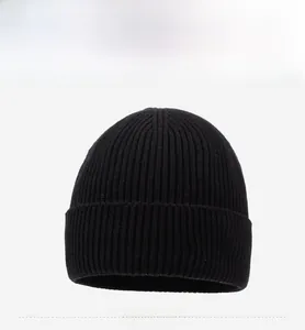 Close-up of black ribbed knit beanie featuring mountain embroidery and fold-over cuff