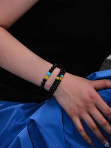 Detailed view of beaded bracelet with black agate, turquoise, and yellow gemstone beads