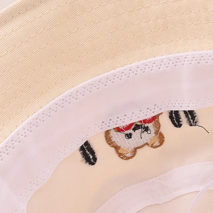 Detailed macro view of children's sun hat interior featuring lace sweatband and bear embroidery