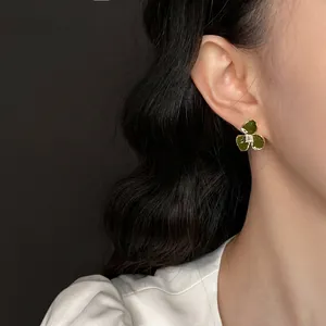 Elegant vintage green clover stud earring with sparkling zircon on model ear