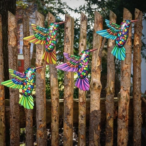 Colorful mosaic metal hummingbirds wall art set displayed on a wooden garden fence