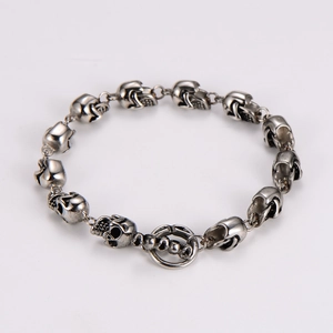 Close-up of silver punk skull link bracelet with detailed 3D gothic metallic skulls