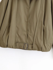 Detail view of olive green bomber jacket featuring adjustable metal buckle and pocket stitching