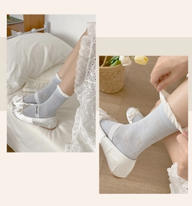 Detail of light blue ruffle socks with beige bows and side brand tag for women