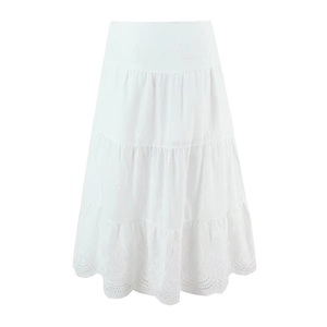 Detailed view of tiered white skirt featuring intricate hollow embroidery and lace hems