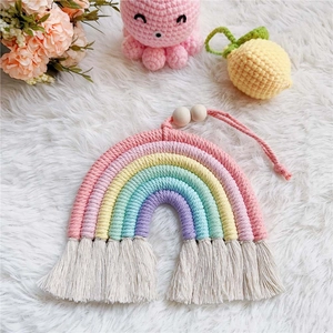 Detail of handmade rainbow wall decor with cotton ropes, wooden beads and tassels