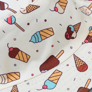 Macro detail of cute colorful cartoon ice cream print on beige cotton bucket hat fabric