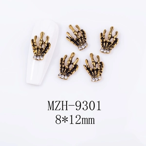 Detailed close-up of retro bronze skeleton hand nail art charm with rhinestones