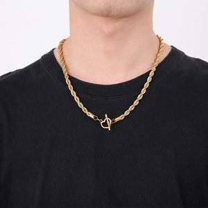 Gold twist chain necklace with heart-shaped OT buckle worn by model on white background