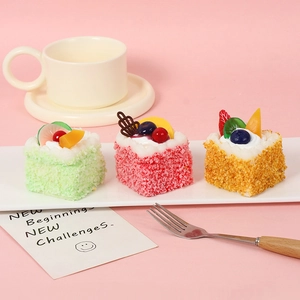 Three realistic PU mousse cake dessert models with fruits on a white tray with coffee cup