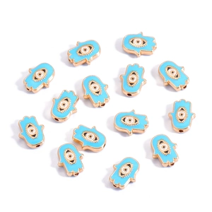 Detailed view of gold-plated Hamsa Hand charms with blue enamel and evil eye center