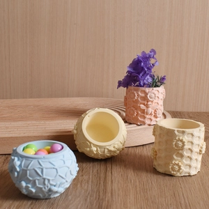 Detailed relief of honeycomb and sunflower patterns on colorful cylindrical resin jars