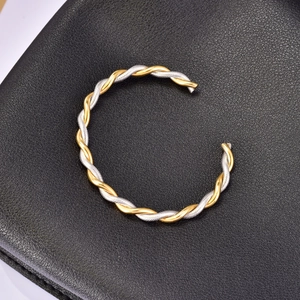 Two-tone twisted wire bangle in gold and silver stainless steel with open cuff design