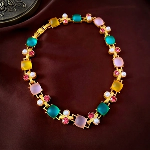 Vintage gold necklace with colorful frosted square stones and white pearls on silk background