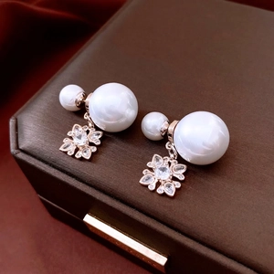 Rose gold double pearl earrings with a crystal-encrusted flower charm on leather
