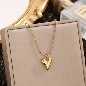 Elegant gold titanium steel heart pendant necklace displayed on a luxury jewelry box