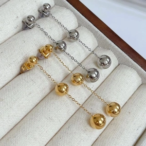 Long ball drop earrings in gold and silver steel finishes with triple bead chain design