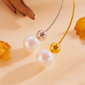 Détail des colliers en acier doré et argenté avec de grosses perles et boules métal