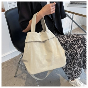 Minimalist beige nylon tote bag shown in a professional commute and lifestyle scene