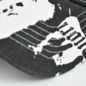 Close-up of black twill cotton visor with white tie-dye print and reinforced stitching