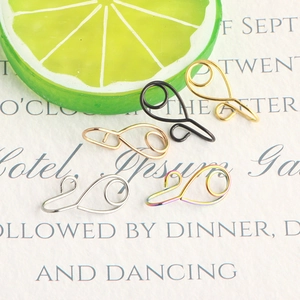 Five colored stainless steel fake nose rings displayed with fresh lime slices on a card