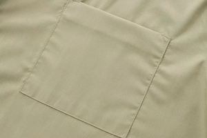 Close-up detail of khaki poplin shirt showing rectangular pocket and precision stitching