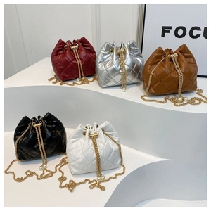 Detail of quilted bucket bags with chain straps and pearl charms in five various colors