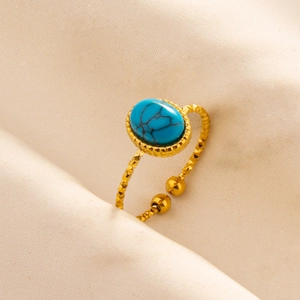 Detail of adjustable gold ring with oval turquoise stone and textured metallic finish