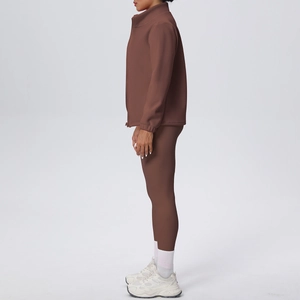 Vista laterale del set da yoga marrone con leggings a vita alta e giacca con zip