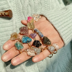 Handmade wire wrapped raw crystal rings featuring citrine and amethyst on model's hand