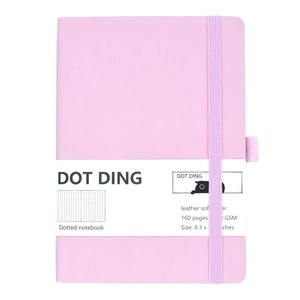 Pink dotted bullet journal with elastic closure and integrated pen holder on white background