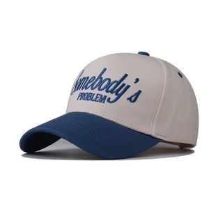 Gros plan sur la broderie 3D Somebody's Problem sur une casquette en coton bicolore