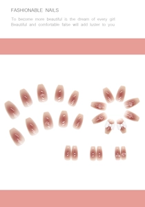 Close-up of pink gradient press-on nails featuring 3D white bows and heart crystals