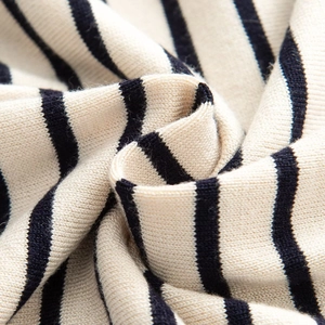Gros plan sur la texture du tricot rayé montrant les détails des mailles beige et noir