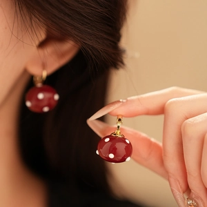 Close-up of vintage French style red polka dot ball earrings with gold-plated clasp